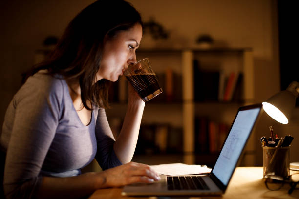 istock Woman working on laptop and drinking coffee at home 1193126250