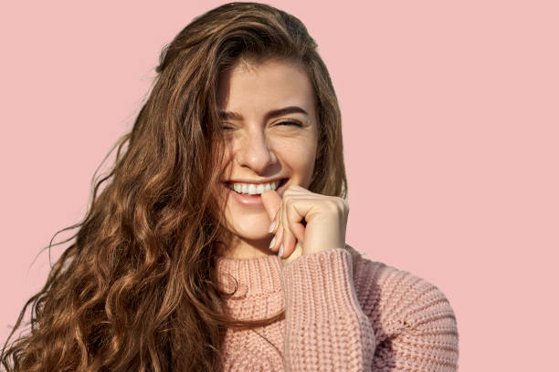 istock female has broad smile, white teeth, bites finger 1193130785