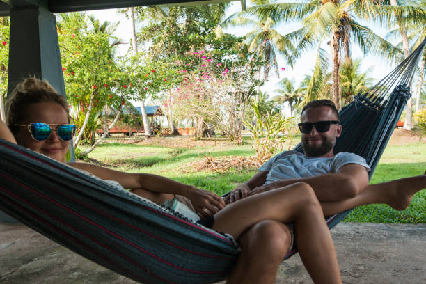 istock Man with a woman lying on a hammock, tropical vibe 1193130827