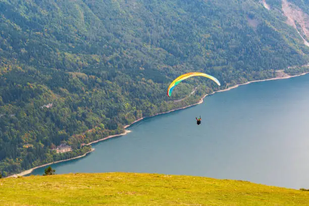 A paraglider flies over Molveno Lake. Italy.