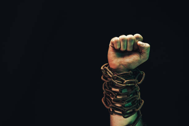 istock Human hand are chained in chains isolated on black background. 1193132990