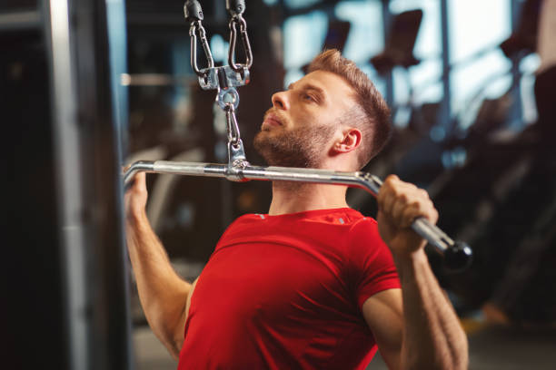 istock Young muscular man pulling up on horizontal bar in a gym 1193133125