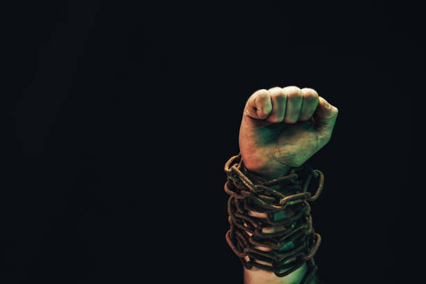 istock Human hand are chained in chains isolated on black background. 1193134462