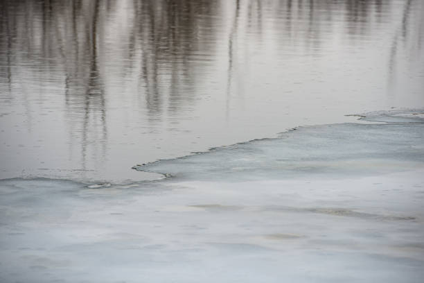 melting ice on the river and reflection in ice. In the countryside. Early spring, March. Web banner.