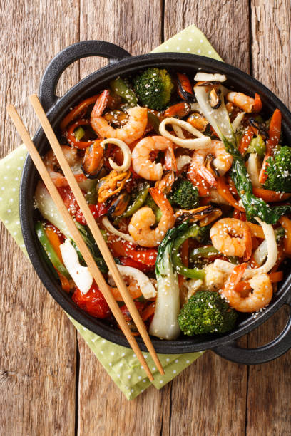 istock seafood stir-fried with fresh vegetables close-up in a pan. Vertical top view 1193137475