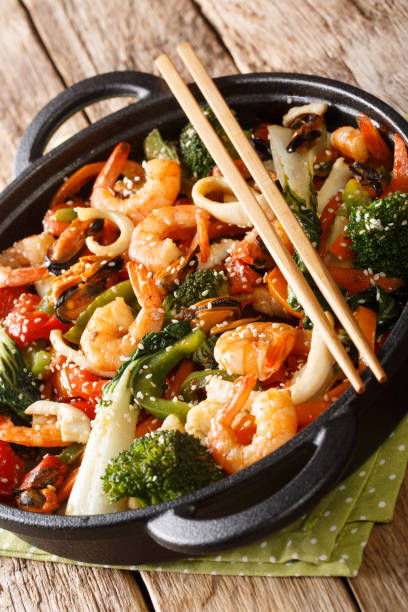 istock seafood stir-fried with fresh vegetables close-up in a pan. vertical 1193137503