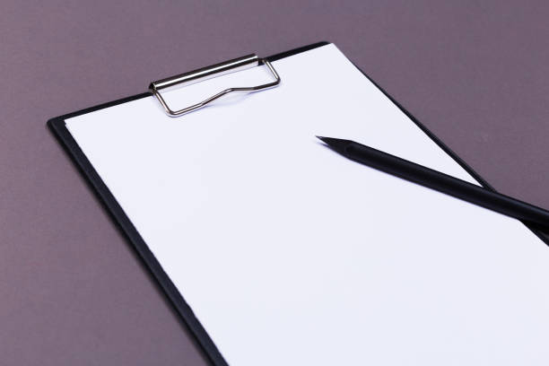 istock Clipboard with white sheet and pen on a colored background. View from above. space for text 1193138367