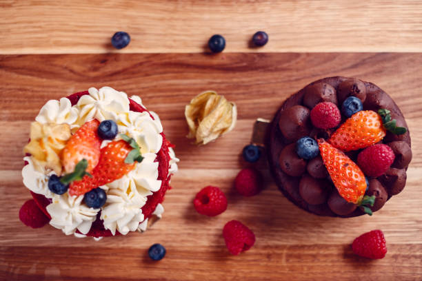 deux petits gâteaux sur la table en bois avec la décoration de fruit, vue supérieure - little cakes photos et images de collection