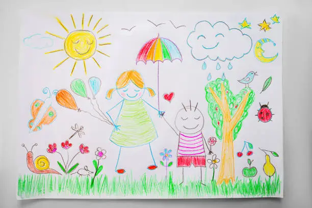 Photo of Child drawing a happy family with color pencils