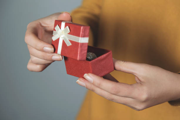 istock woman hand holding box with ring 1193139937