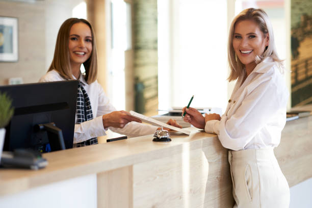 istock Receptionist and businesswoman at hotel front desk 1193140083