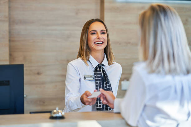 Receptionist and businesswoman at hotel front desk Picture of receptionist and businesswoman at hotel front desk guest stock pictures, royalty-free photos & images