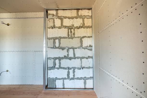 istock Unfinished brick wall in a room under construction prepared for drywall plates frame installation. 1193141650