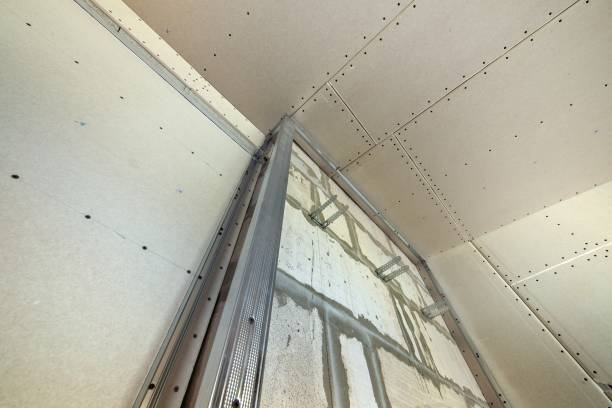 istock Unfinished brick wall in a room under construction prepared for drywall plates frame installation. 1193141673