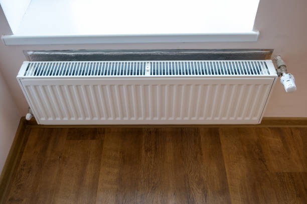 istock White metal heating radiator mounted on a wall in room interior. 1193141770