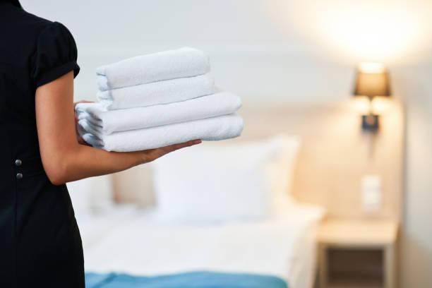 maid with fresh towels in hotel room - hotel occupation imagens e fotografias de stock