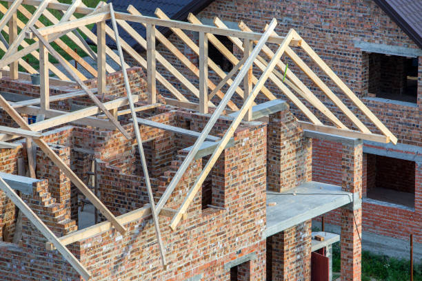 istock Unfinished brick house with wooden roof structure under construction. 1193143542