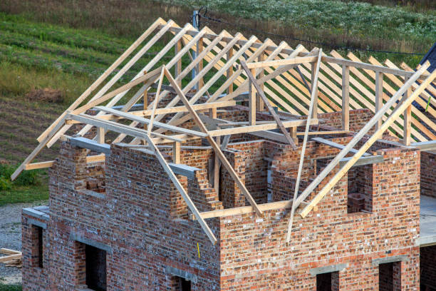 istock Unfinished brick house with wooden roof structure under construction. 1193143548