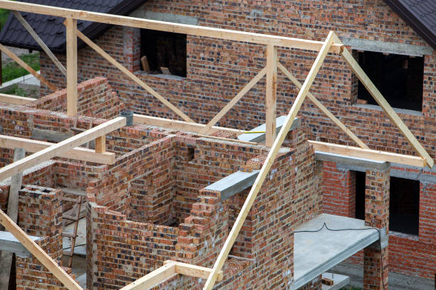 istock Unfinished brick house with wooden roof structure under construction. 1193143584