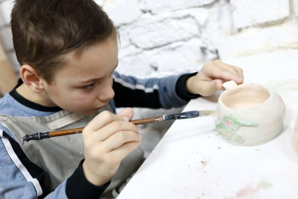 istock Kid painting clay cup 1193145013