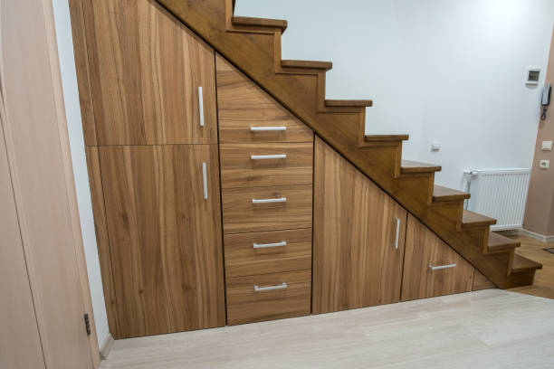 istock Modern architecture interior with luxury hallway with glossy wooden stairs in multi-storey house. Custom built pullout cabinets on glides in slots under stairs. Use of space for storage. 1193145478