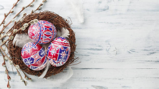Pysanky, decorated Easter eggs in the nest Pysanky in the nest, pussy willow and feathers on wooden background. Easter eggs, painted in red, blue and white, national flag colors of many countries. wide format, top view, copy space croatian culture photos stock pictures, royalty-free photos & images