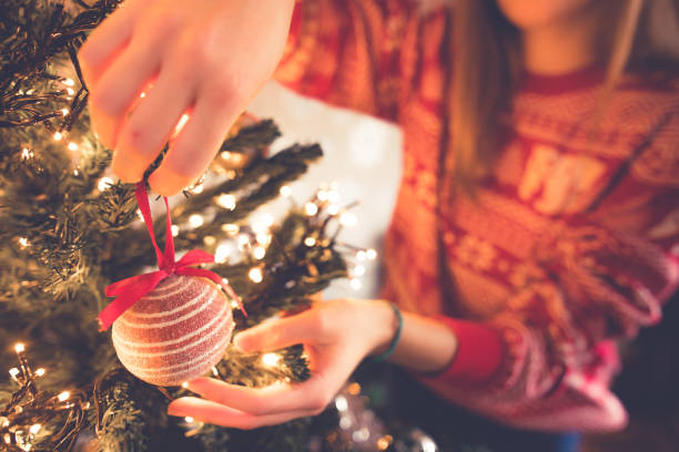 istock Young woman decorating Christmas tree in her home. Hands close up 1193149143
