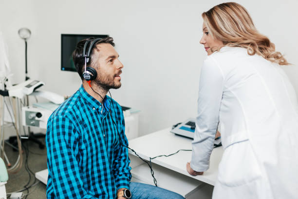 Medical hearing examination Middle age man at medical examination or checkup in otolaryngologist's office audiologist stock pictures, royalty-free photos & images