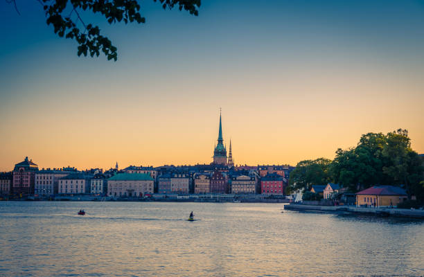 Old quarter Gamla Stan with traditional buildings, Stockholm, Sweden Old historical town quarter Gamla Stan with traditional typical buildings with colorful walls, park of Skeppsholmen island, jet ski and boat on Lake Malaren water at sunset, Stockholm, Sweden strommen stock pictures, royalty-free photos & images