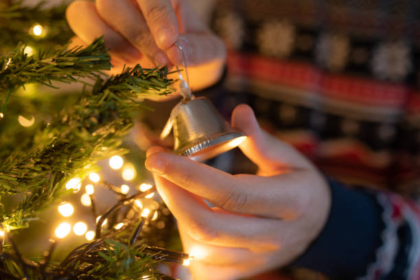 istock Young men decorating Christmas tree in her home. Hands close up 1193151684