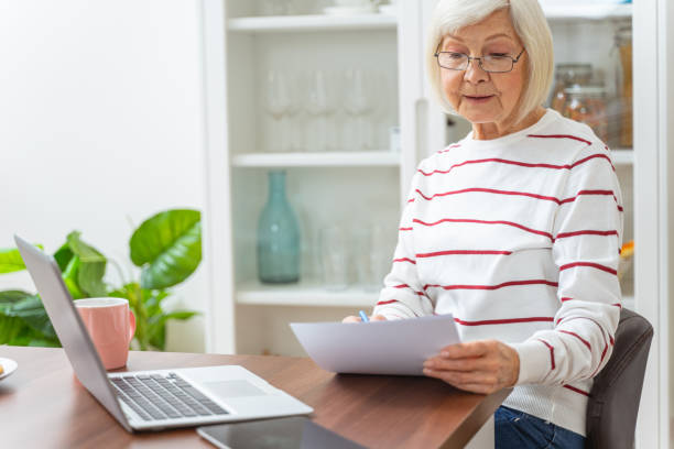 istock Serious elderly lady sitting at the laptop 1193156379