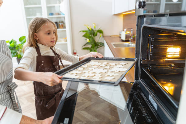 istock Young Caucasian lady holding a cookie sheet 1193156525