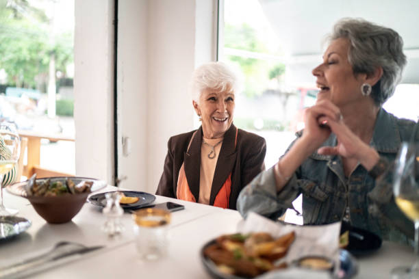 istock Senior friends having lunch in a restaurant, talking and laughing 1193156816
