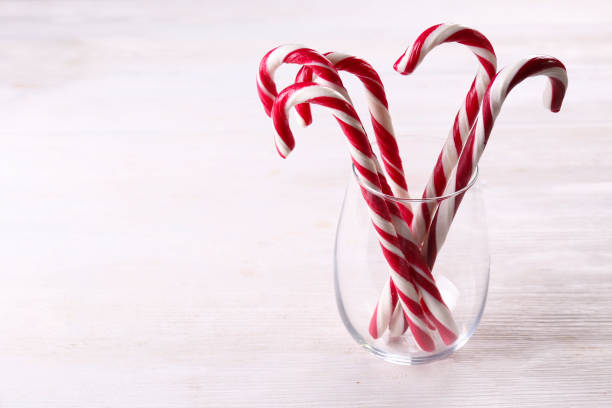 bonbons durs rouges et blancs traditionnels sous forme de canne. - stick of hard candy candy striped toughness photos et images de collection