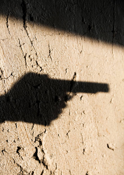 istock Shadow of the hand pointing a gun 1193156896