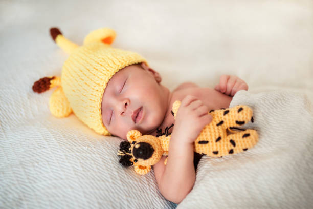istock Cute newborn boy with giraffe doll 1193156959