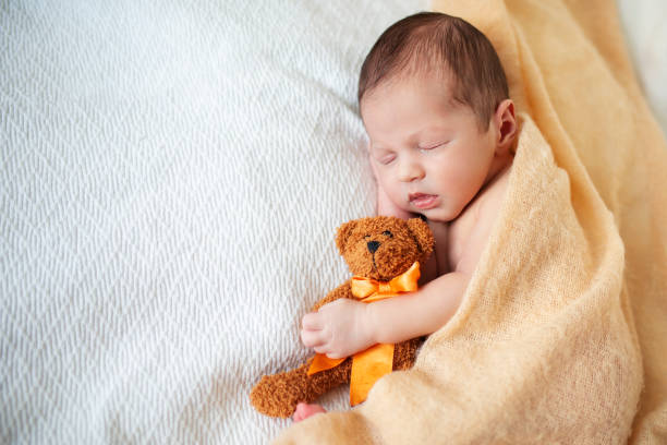 istock Peaceful baby lying on a bed with his teddy bear 1193158219