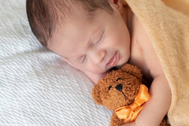 istock Sleeping newborn baby on a blanket with a teddy 1193158737