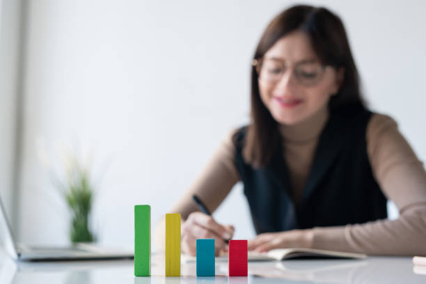 istock Multi-color cube chart on desk on background of female banker making notes 1193161561