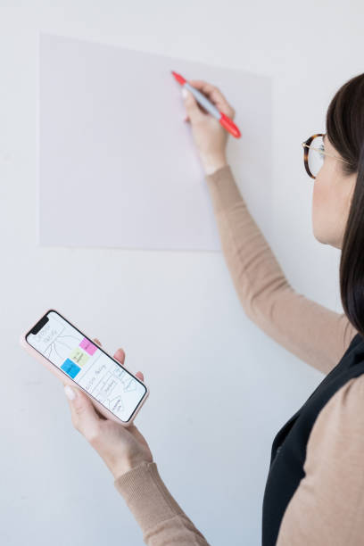 istock Young business coach holding smartphone with flow chart before presentation 1193161587
