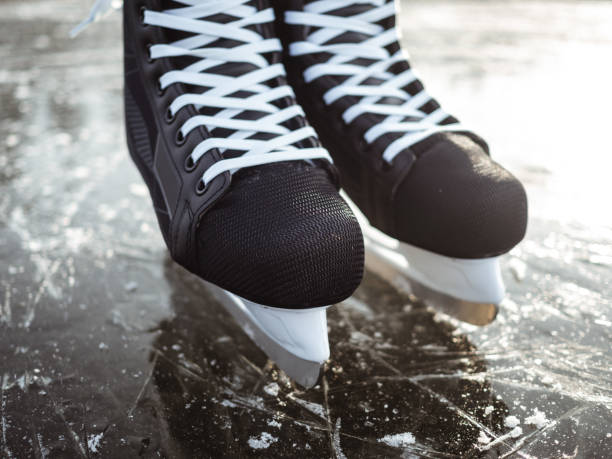 istock Black ice skates close up on ice 1193162640
