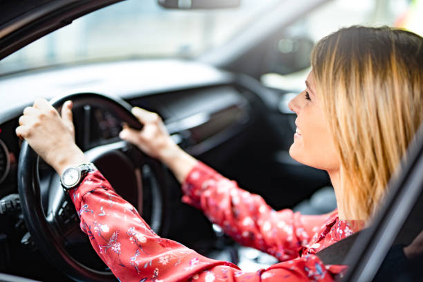 istock Happy young woman driving a car. 1193164283