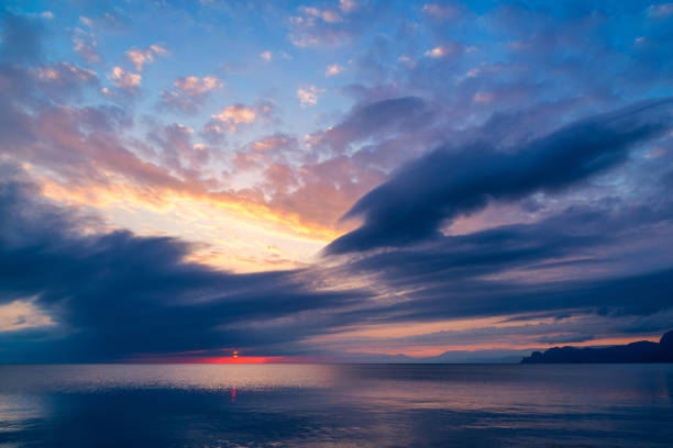 istock Beautiful red sunset in blue clouds over a quiet sea 1193165381