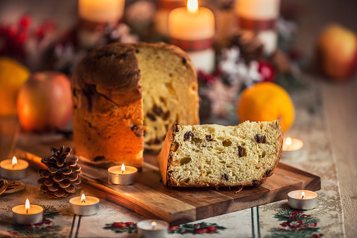 Delicious panettone on christmas table wit decorations and advent wreath and candles.