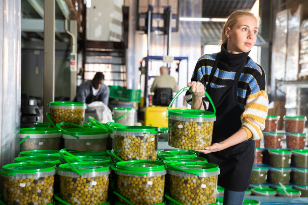 istock Woman arranging plastic buckets with pickled olives 1193167648