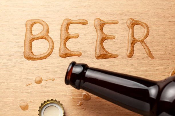 Beer bottle and spilled drink on the table.
