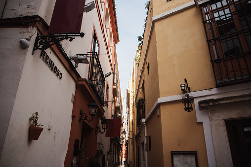 Typical architecture in Santa Cruz, an area in the city center of Seville, Spain, with narrow streets and old, colorful houses