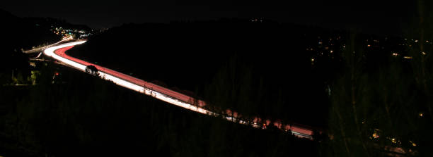 Time lapse of traffic on 405 freeway in Sepulveda pass from side street Time lapse of traffic on 405 freeway in Sepulveda pass from side street san diego freeway stock pictures, royalty-free photos & images