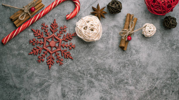 istock Christmas  dark aged cement background with red decorations wrapped in a wrapper with ribbons, gifts, snowflakes, striped candy, and rattan balls of white and brown colors 1193172221