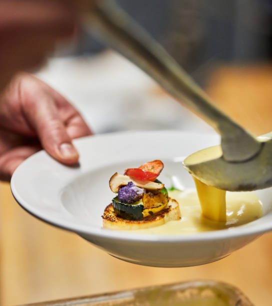 istock A server laddling delicata squash soup with wood grilled fall vegetable 1193177003